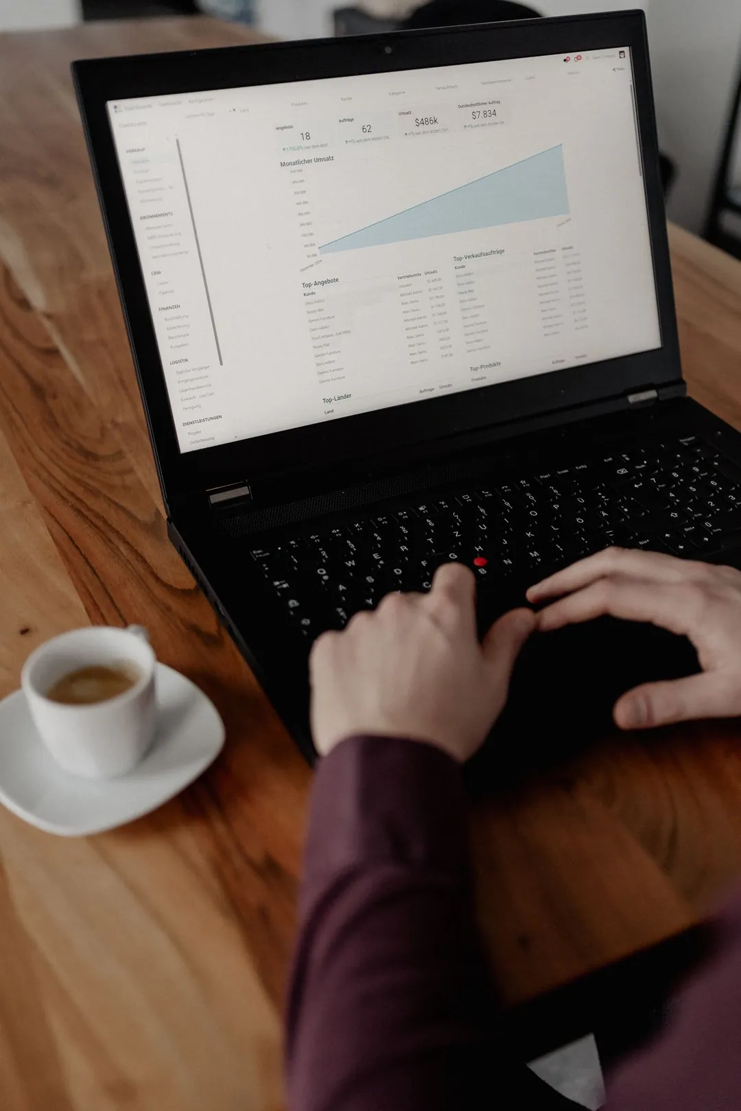 Hands on a laptop keyboard, an Odoo dashboard on the screen